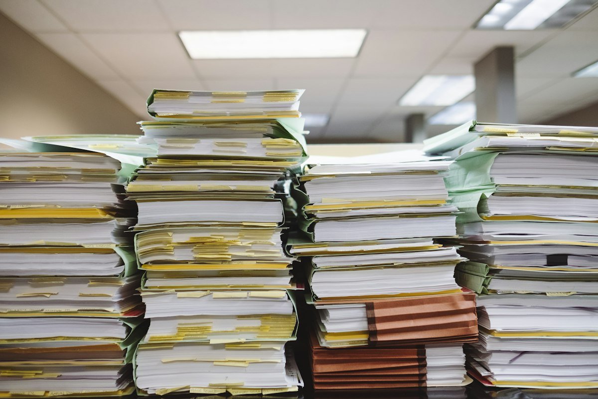Pilas de documentos y carpetas de archivo, ejemplo de información que llevarás a tu contador