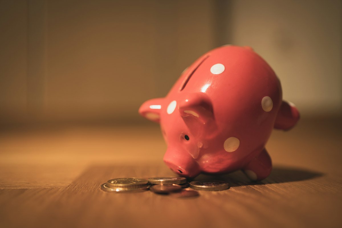 Alcancía de cerdito rosa sobre una mesa de madera, símbolo del ahorro dentro de tu presupuesto mensual