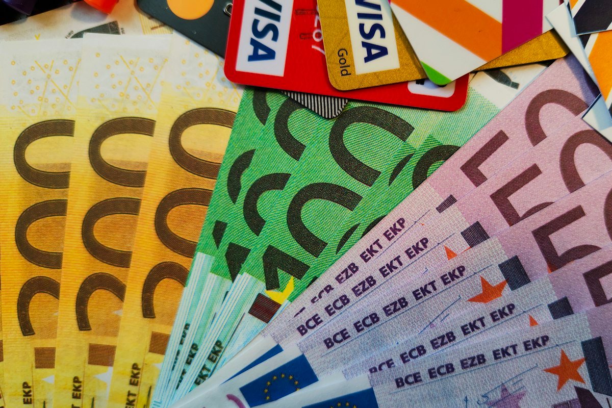 Billetes y tarjetas de crédito sobre una mesa, deudas por ordenar del saldo menor al mayor