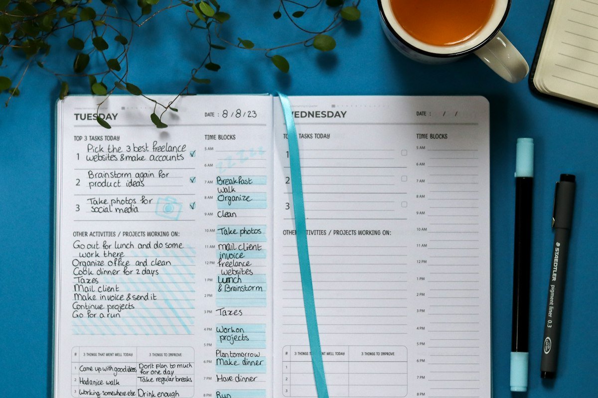 Cuaderno con una lista de preguntas y una pluma junto a una taza de té para elegir a tu contador