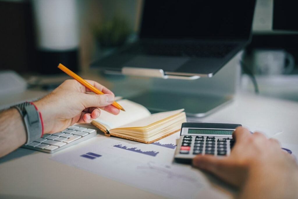 Calculadora y cuaderno sobre un escritorio para calcular el punto de equilibrio de un negocio