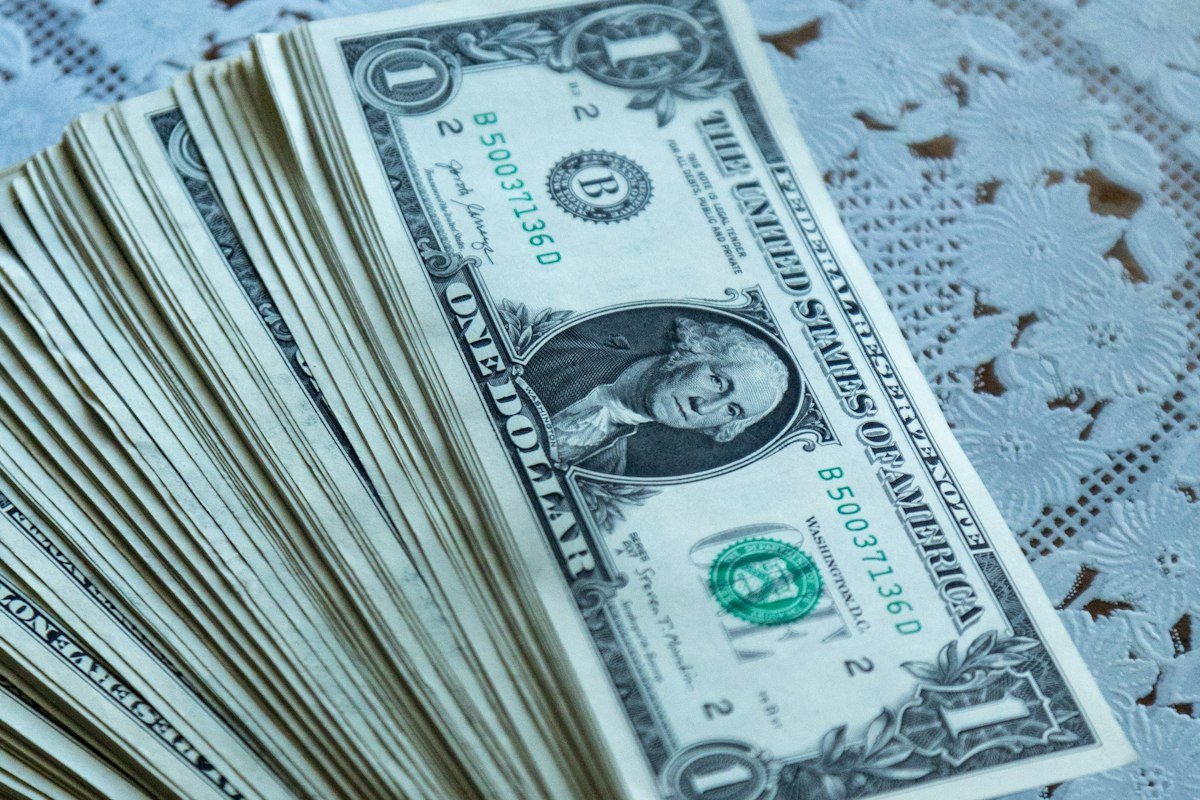 Pila de billetes sobre una mesa, dinero que se va en intereses si solo pagas el mínimo