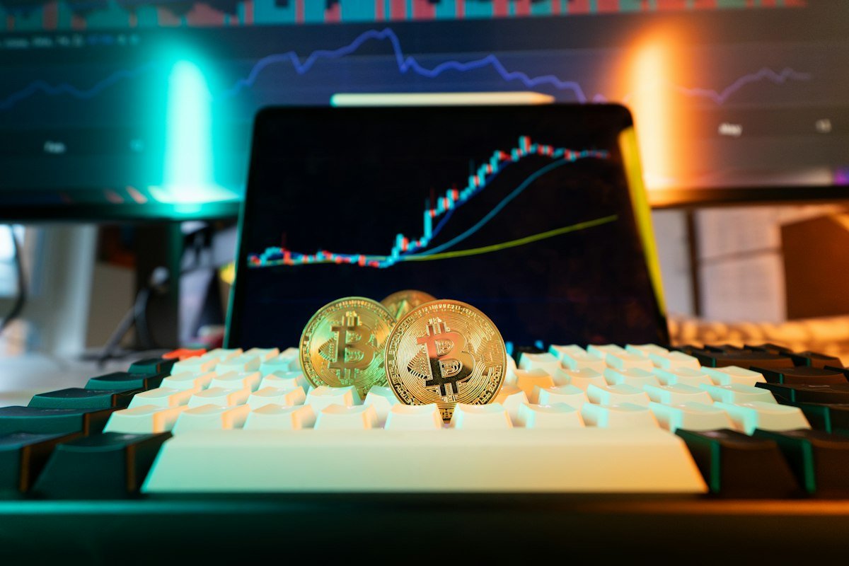Monedas de bitcoin sobre un teclado con gráficas del mercado, tema de préstamos con bitcoin como garantía