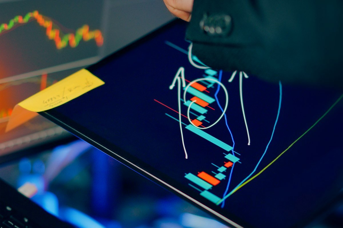 Persona analizando gráficas del mercado en varias pantallas, seguimiento de una plataforma cripto que cierra