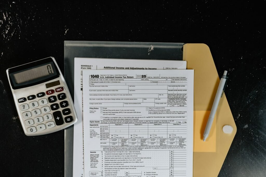 Calculadora y formatos de impuestos sobre una superficie oscura para organizar comprobantes fiscales